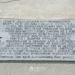 Tablica informacyjna umieszczona na budynku dworu